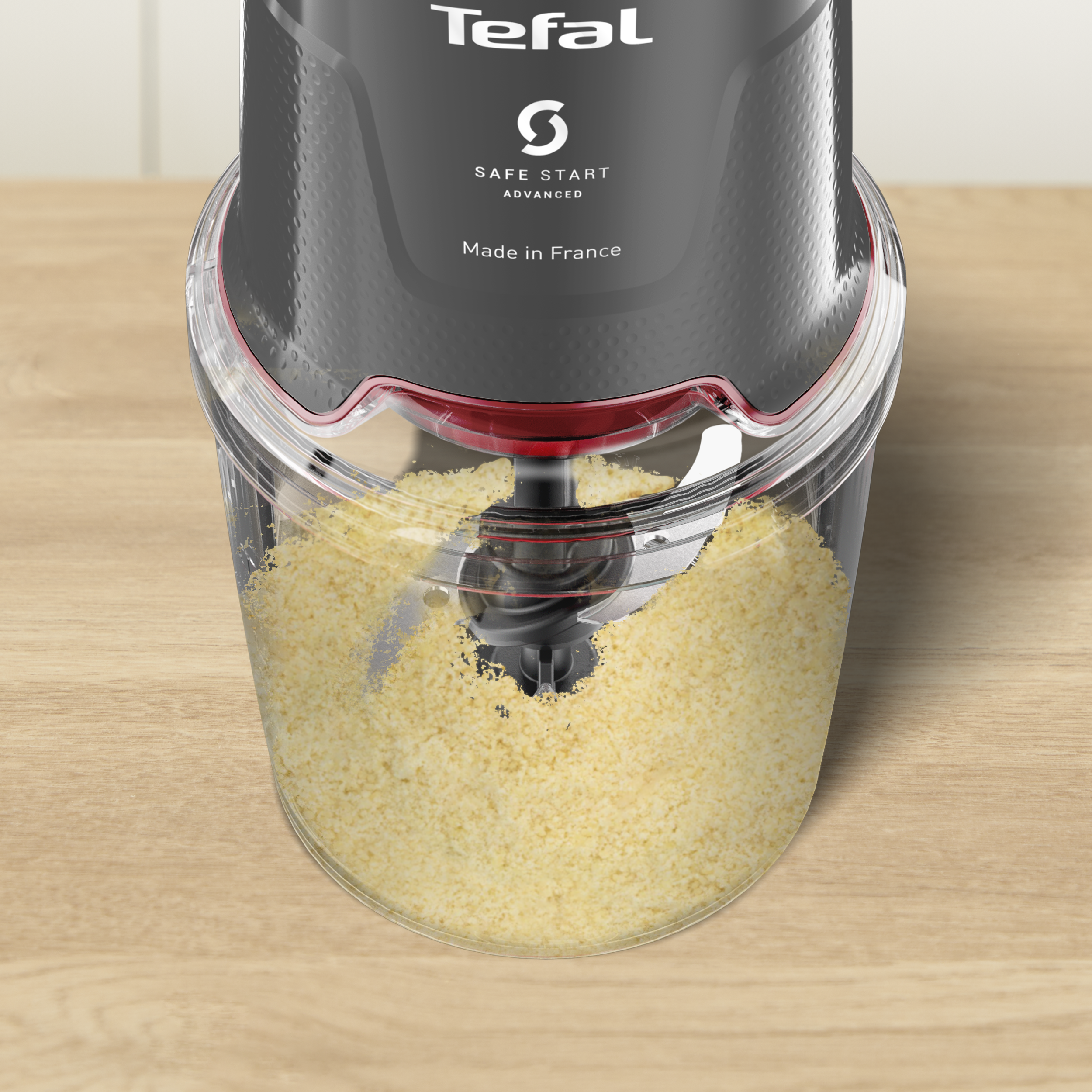 Egy Tefal konyhai robotgép fa felületen. Sárga anyagot tartalmaz. A teteje fekete, a márkajelzéssel.