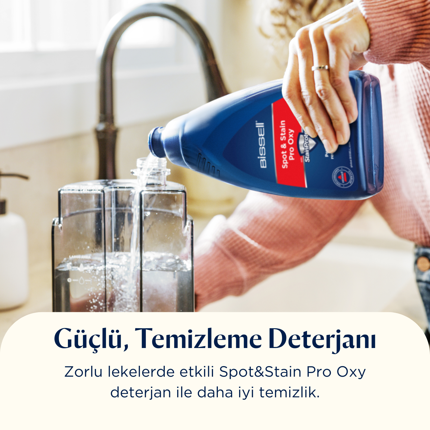 Bir kişi, mutfakta şeffaf bir kaba bir şişeden mavi temizlik solüsyonu döküyor.
