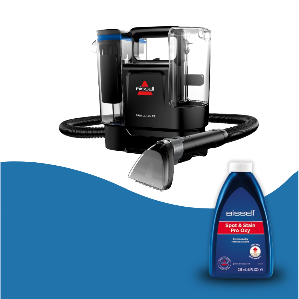 Bir hortum ve temizleme başlığına sahip siyah bir Bissell SpotClean C5 ve bir şişe Spot & Stain Pro Oxy temizleyici.