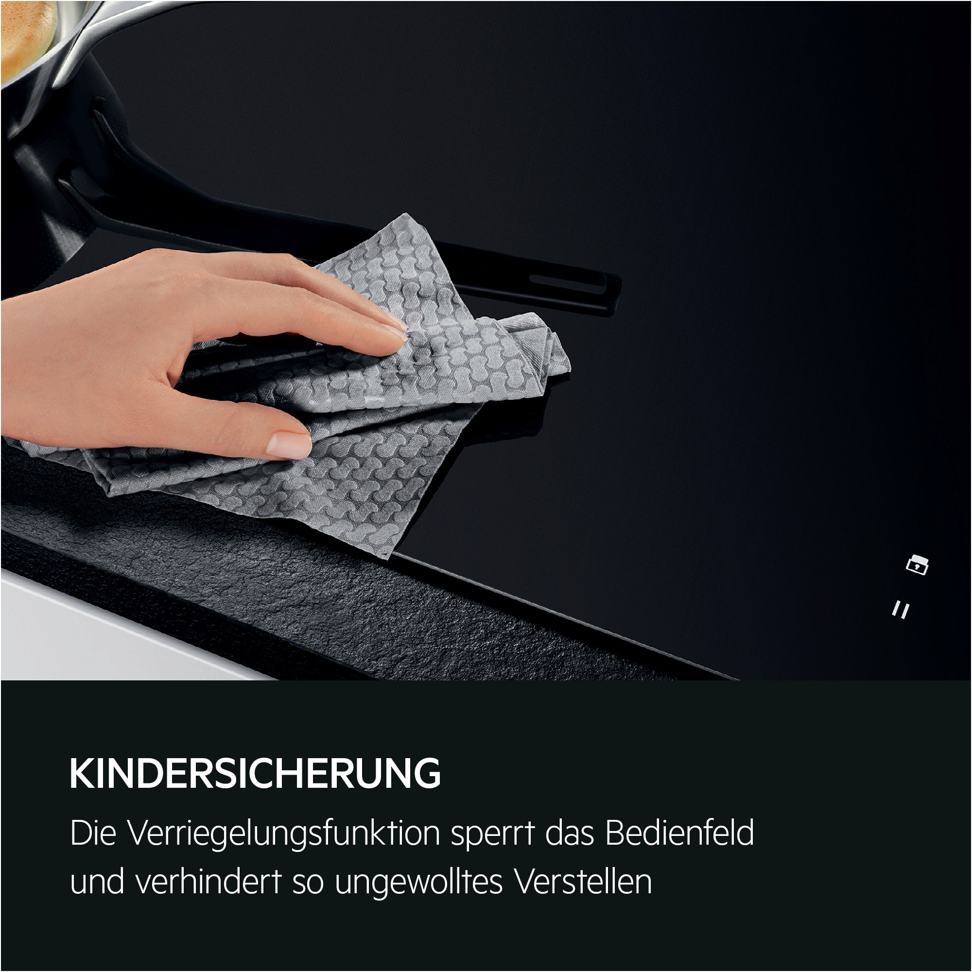Eine Hand wischt eine schwarze Oberfläche mit einem grauen Tuch ab. Die Oberfläche hat eine Kindersicherung.