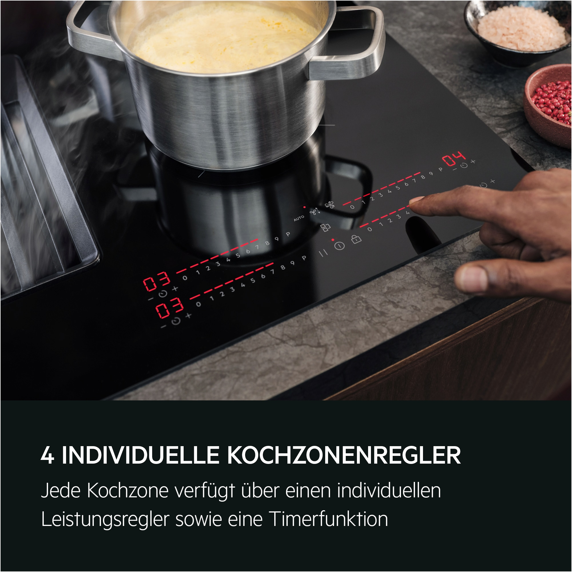 Schwarzes Kochfeld mit Topf, Hand berührt Bedienelemente. Rote Zahlen zeigen Leistungsstufen. Schalen mit Salz und Beeren im Hintergrund.