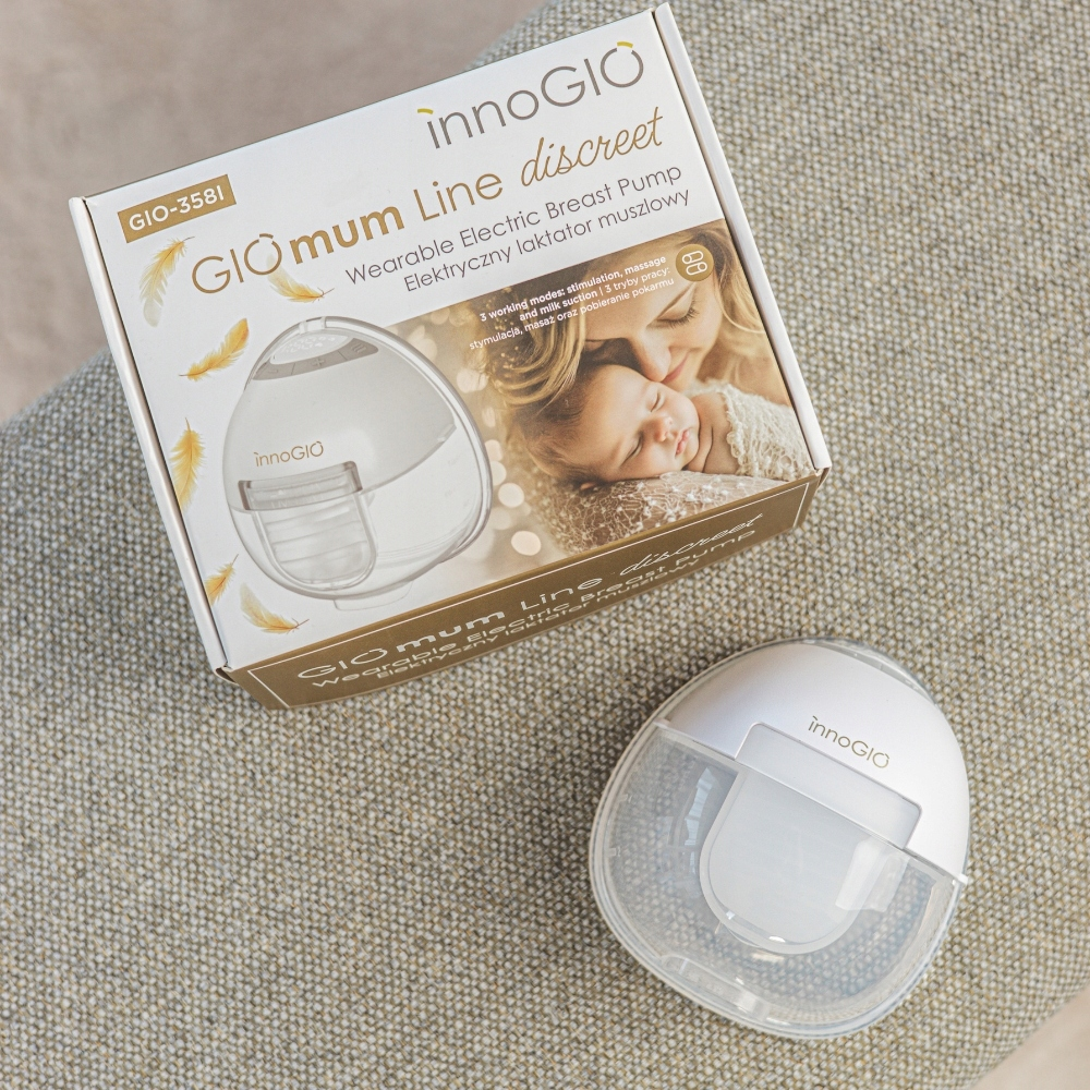 Laktator i jego pudełko na teksturowanej powierzchni. Na pudełku zdjęcie matki i dziecka.