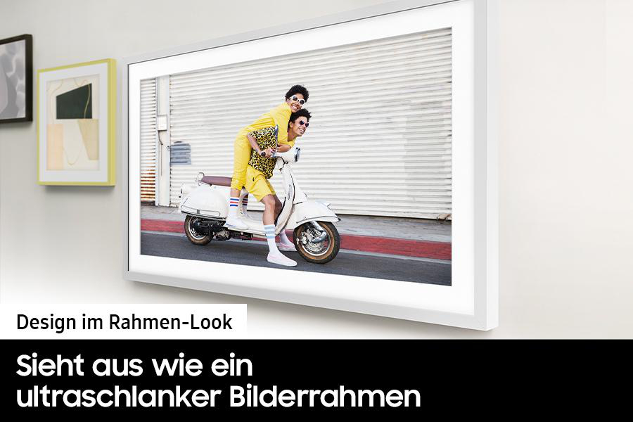 Zwei Personen auf einem weißen Roller. Einer fährt, der andere sitzt hinten und trägt eine Sonnenbrille und einen gelben Anzug. Der Hintergrund ist ein weißer Rollladen.