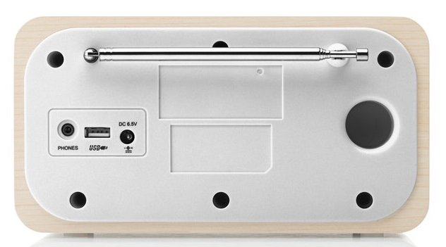 Widok z tyłu radia. Posiada biały panel centralny z portami, chowaną antenę i drewnianą ramę.