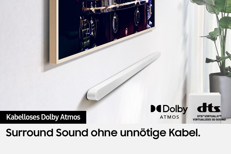 Eine weiße Soundbar unter einem Fernseher mit Dolby Atmos und DTS Virtual:X. Der Text lautet 'Surround Sound ohne unnötige Kabel'.