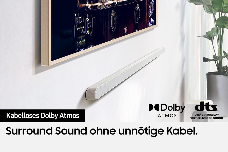 Eine weiße Soundbar ist unter einem Fernseher montiert. Die Szene enthält Logos für Dolby Atmos und DTS, mit Text für Surround-Sound.