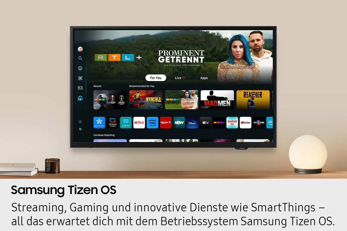 Ein Fernseher zeigt eine Streaming-Oberfläche mit App-Symbolen. Der Bildschirm zeigt eine Sendung mit einer Frau mit blauen Haaren.
