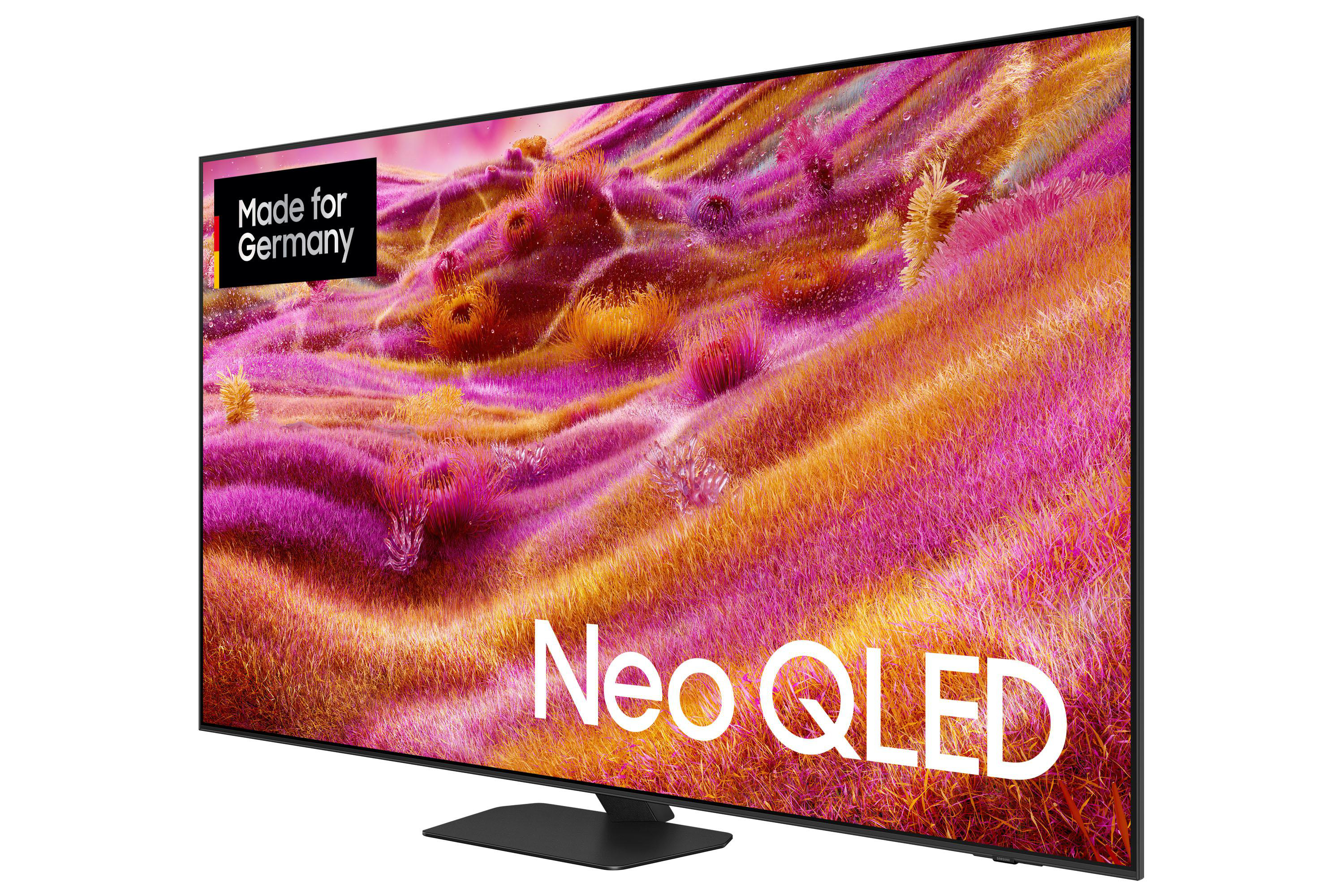 Ein Neo QLED-Fernseher zeigt ein farbenfrohes, abstraktes Bild. Der Fernseher hat einen schwarzen Rahmen und einen schwarzen Ständer.