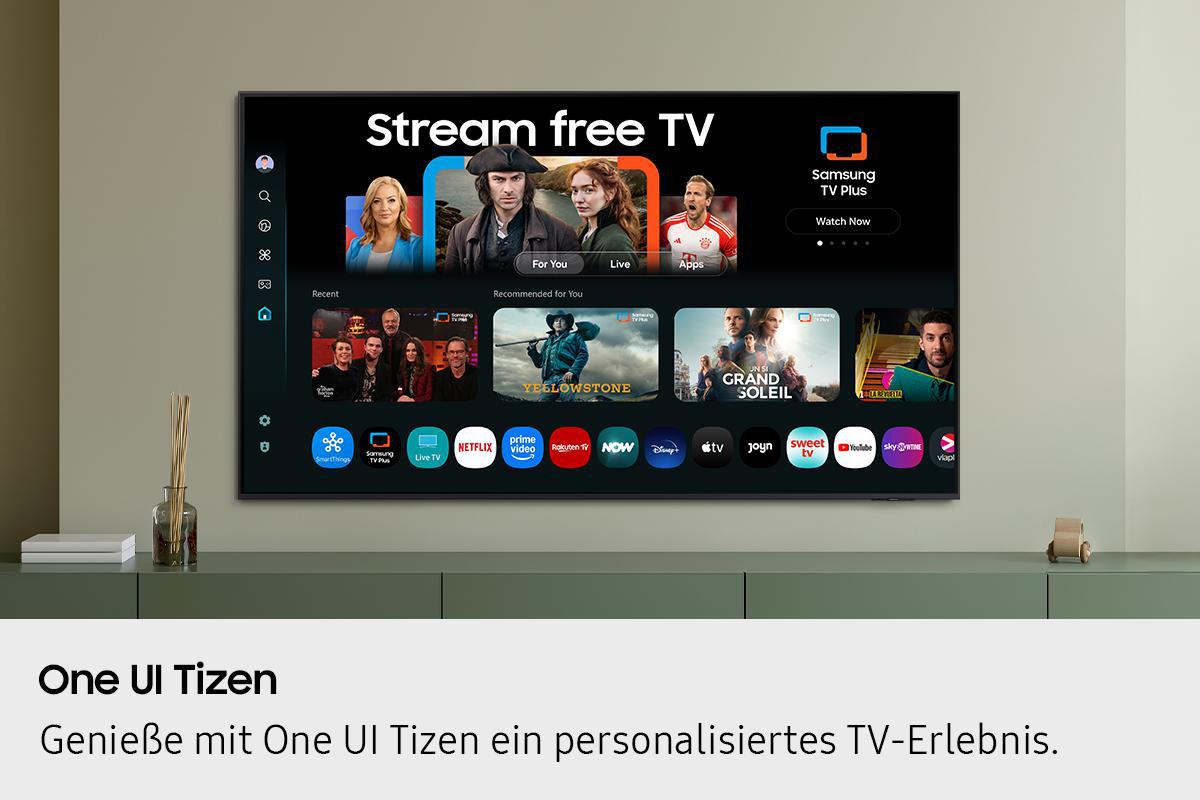 Ein Fernsehbildschirm zeigt Streaming-Optionen. Darunter steht ein grüner Schrank mit Dekoration. Der Fernseher hängt an einer hellgrauen Wand.
