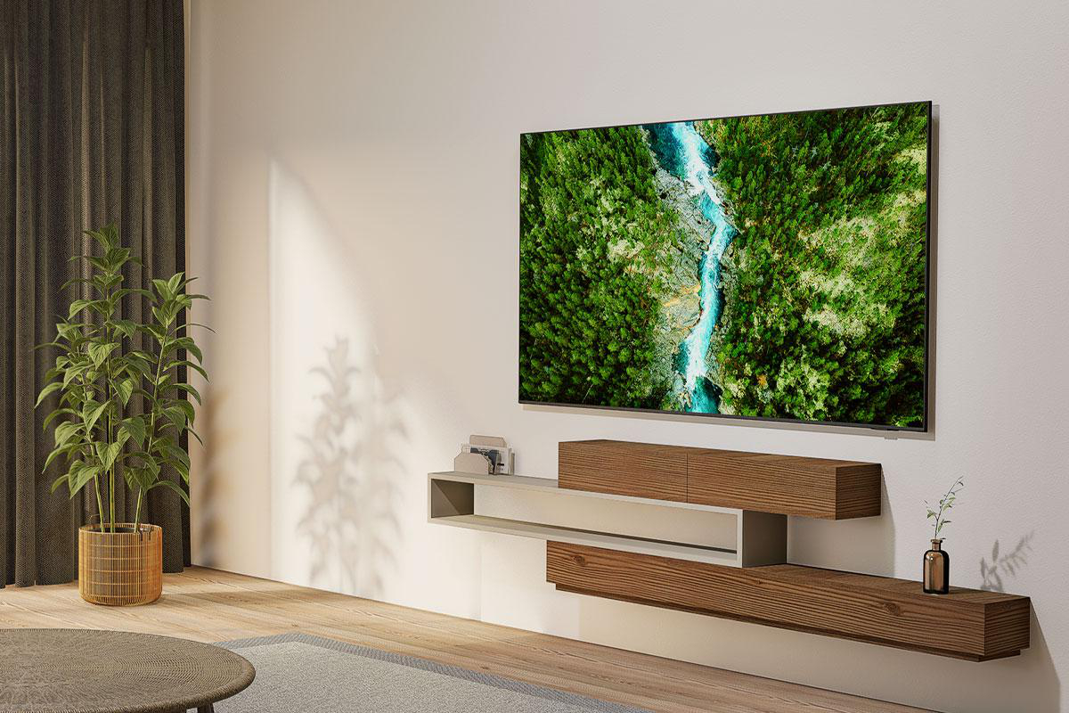 Ein modernes Wohnzimmer mit einem großen Fernseher, der eine Flussszene zeigt, einem Holzregal, einer Pflanze und einem runden Tisch.