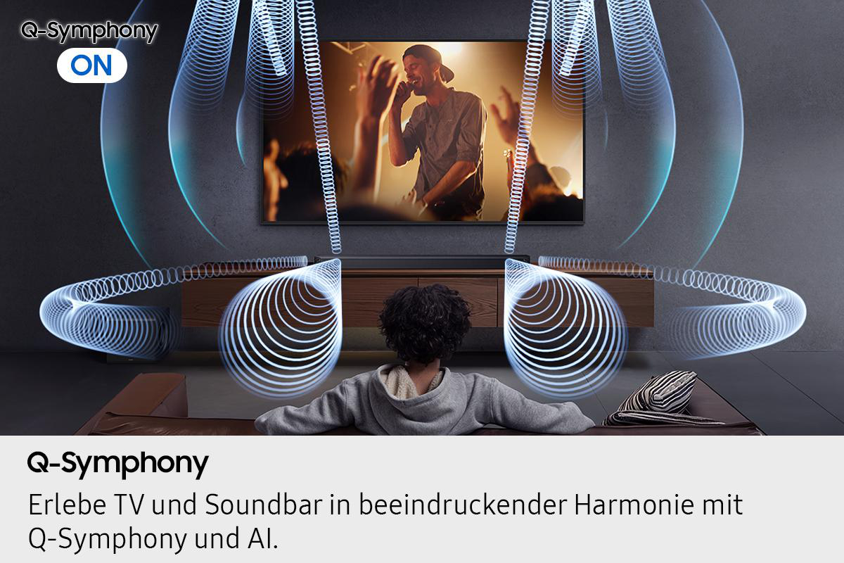 Eine Person sieht fern, auf dem ein Sänger zu sehen ist. Schallwellen gehen vom Fernseher und einer Soundbar aus. Der Text 'Q-Symphony' erscheint.