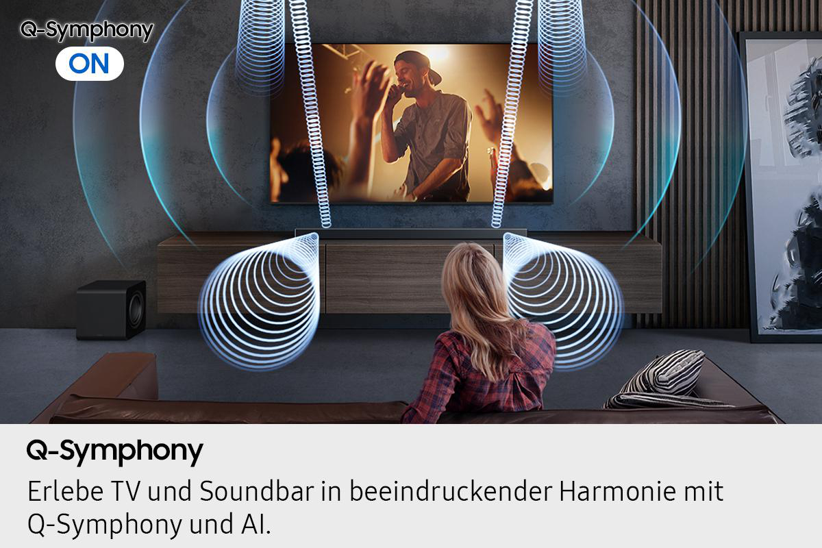 Eine Frau schaut fern. Wellen kommen vom Fernseher und Soundbar. Die Worte 'Q-Symphony ON' sind sichtbar.