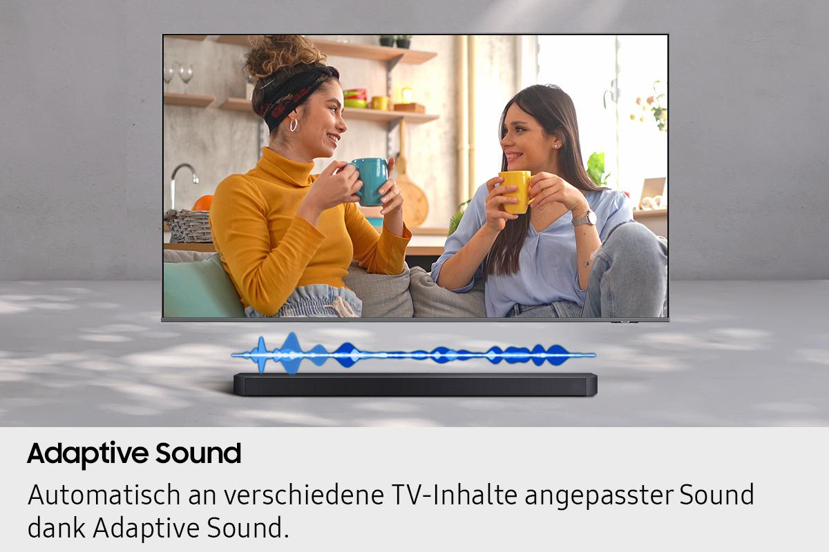Zwei lächelnde Frauen, die Tassen halten, vor einem Fernseher. Soundbar darunter mit Schallwellengrafik. Adaptiver Sound-Text unten.