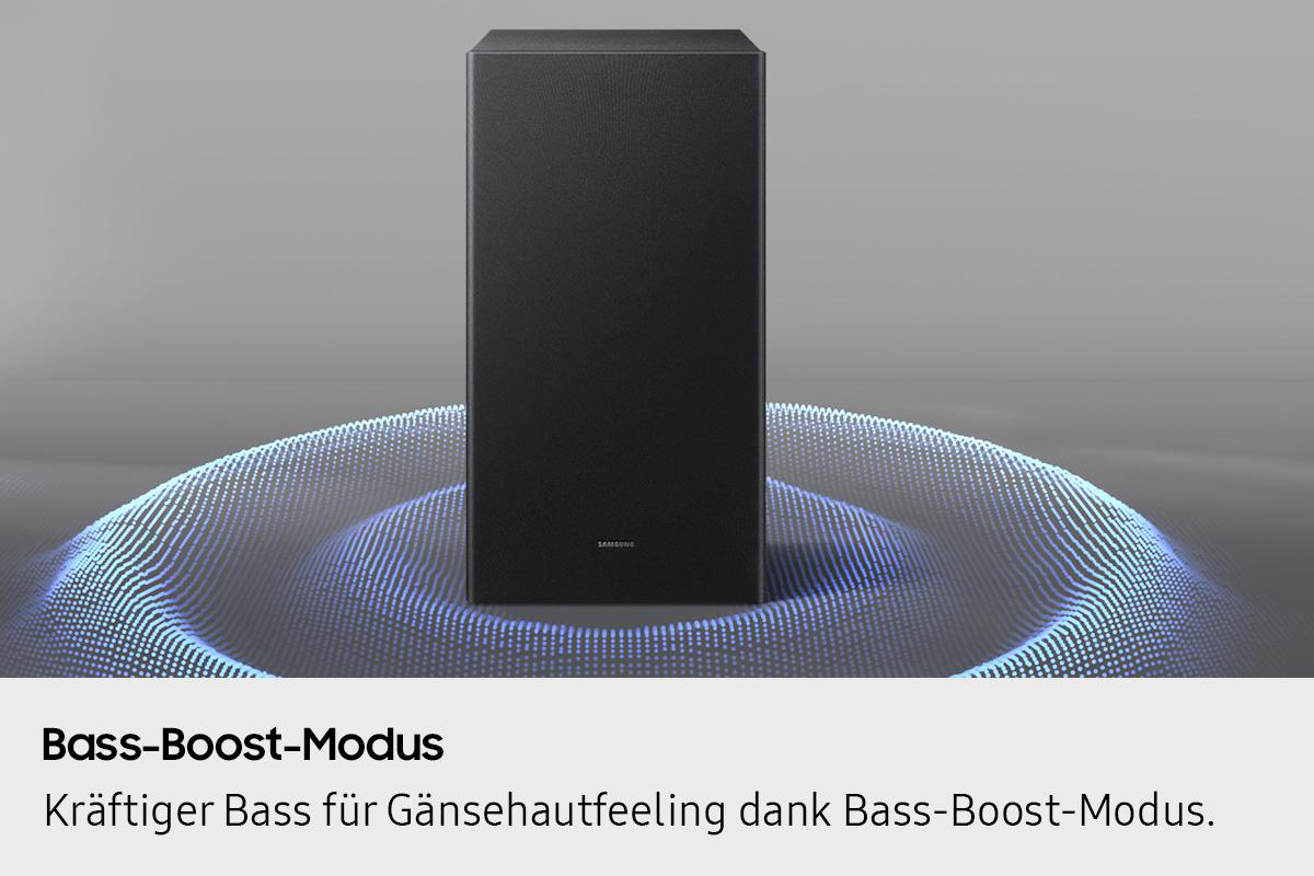 Ein schwarzer, rechteckiger Subwoofer steht auf einem wellenförmigen blauen Lichtmuster. Das Samsung-Logo ist sichtbar. Text: Bass-Boost-Modus.