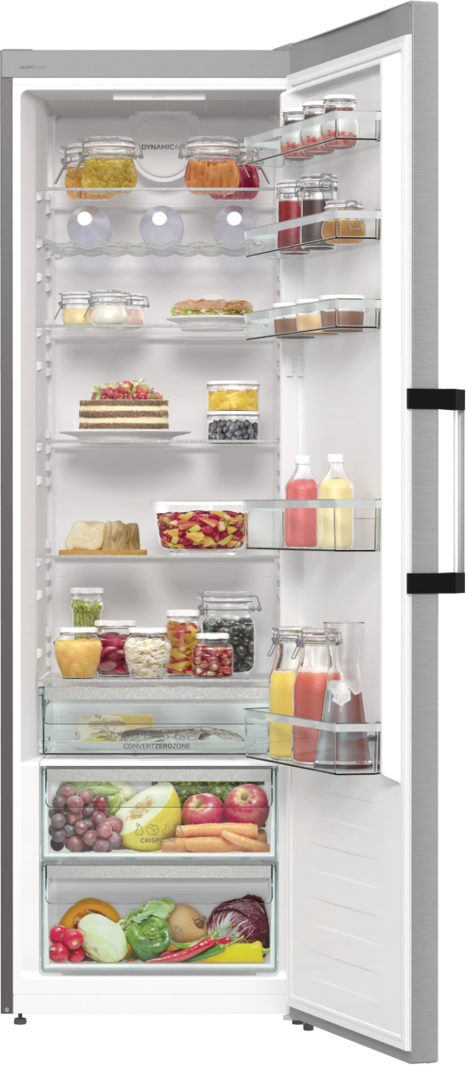 Otwarta lodówka wypełniona produktami spożywczymi, takimi jak słoiki, ciasta, owoce i warzywa. Drzwi są otwarte, widać zawartość.