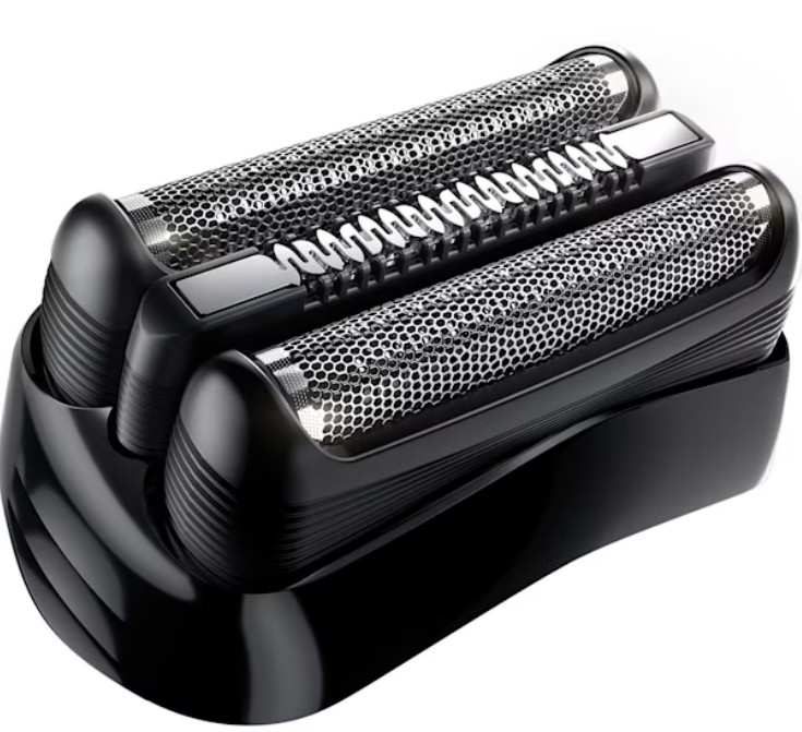 Zbliżenie czarnej głowicy golarki elektrycznej. Ma trzy części: dwie siatki z centralnym trymerem. Podstawa jest również czarna i błyszcząca.