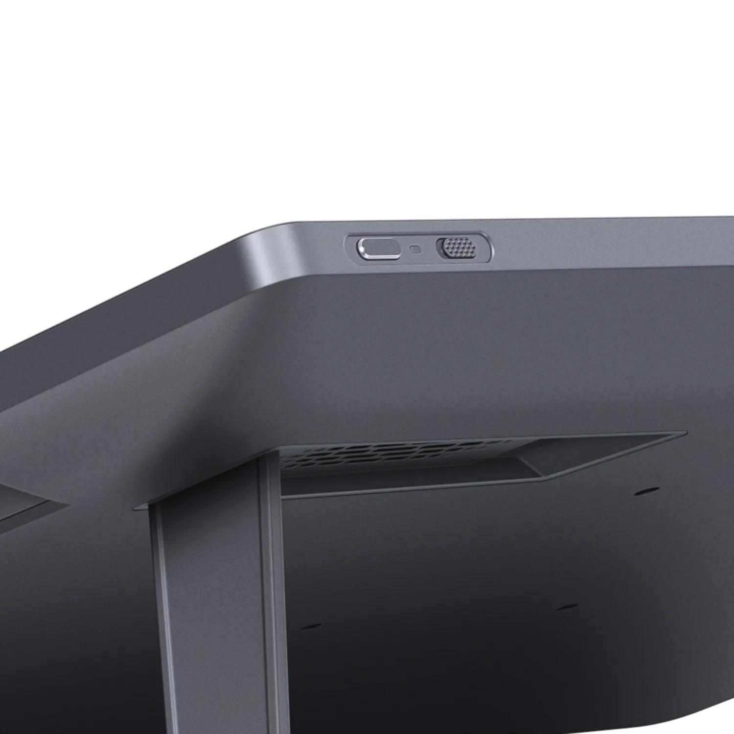 Zbliżenie szarego, prostokątnego urządzenia. Posiada przycisk zasilania, głośnik i szczeliny wentylacyjne. Białe tło.