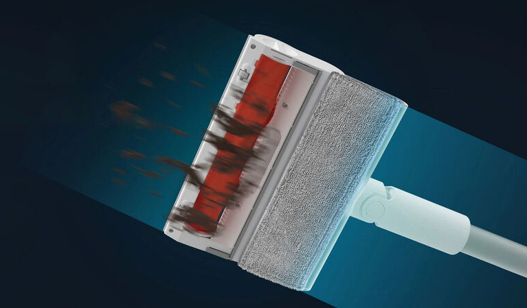 Pokazano biało-szarą głowicę odkurzacza, czyszczącą brud. Szczotka jest czerwona. Tło jest niebieskie.