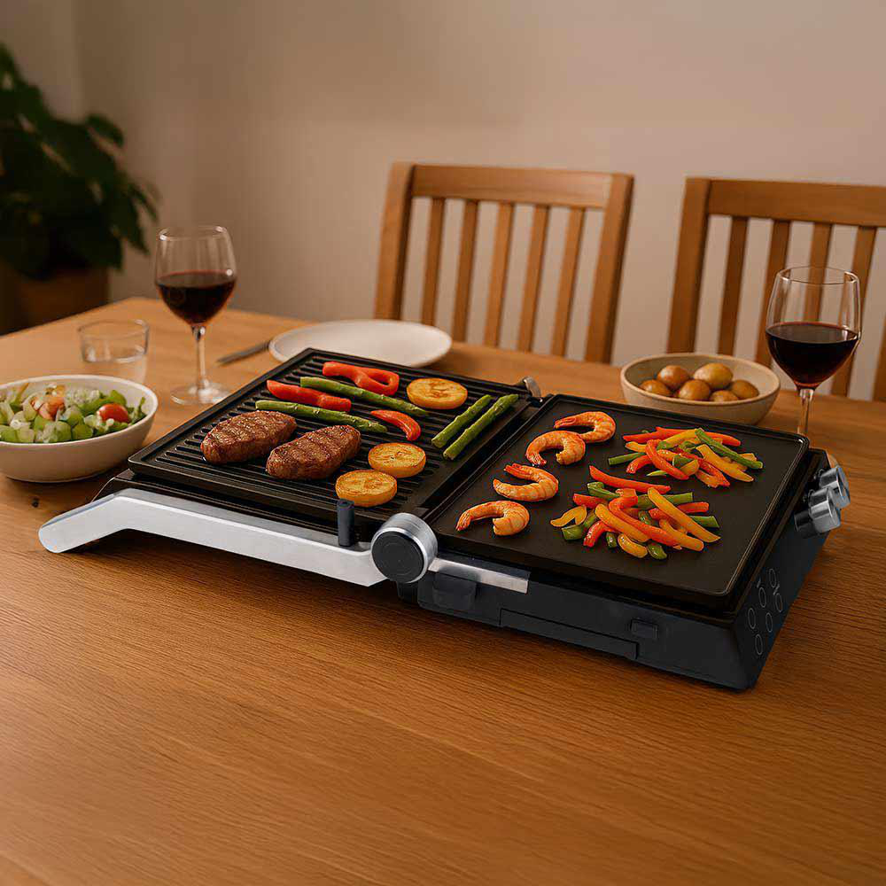 Ein Grill mit Steaks, Gemüse und Garnelen. Weingläser, Salat und Kartoffeln stehen auf einem Holztisch.