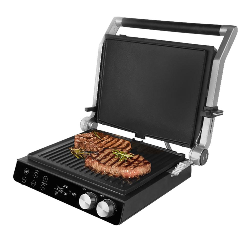 Ein offener Elektrogrill mit zwei Steaks. Der Grill ist schwarz und silber. Steaks sind mit Kräutern gegrillt.