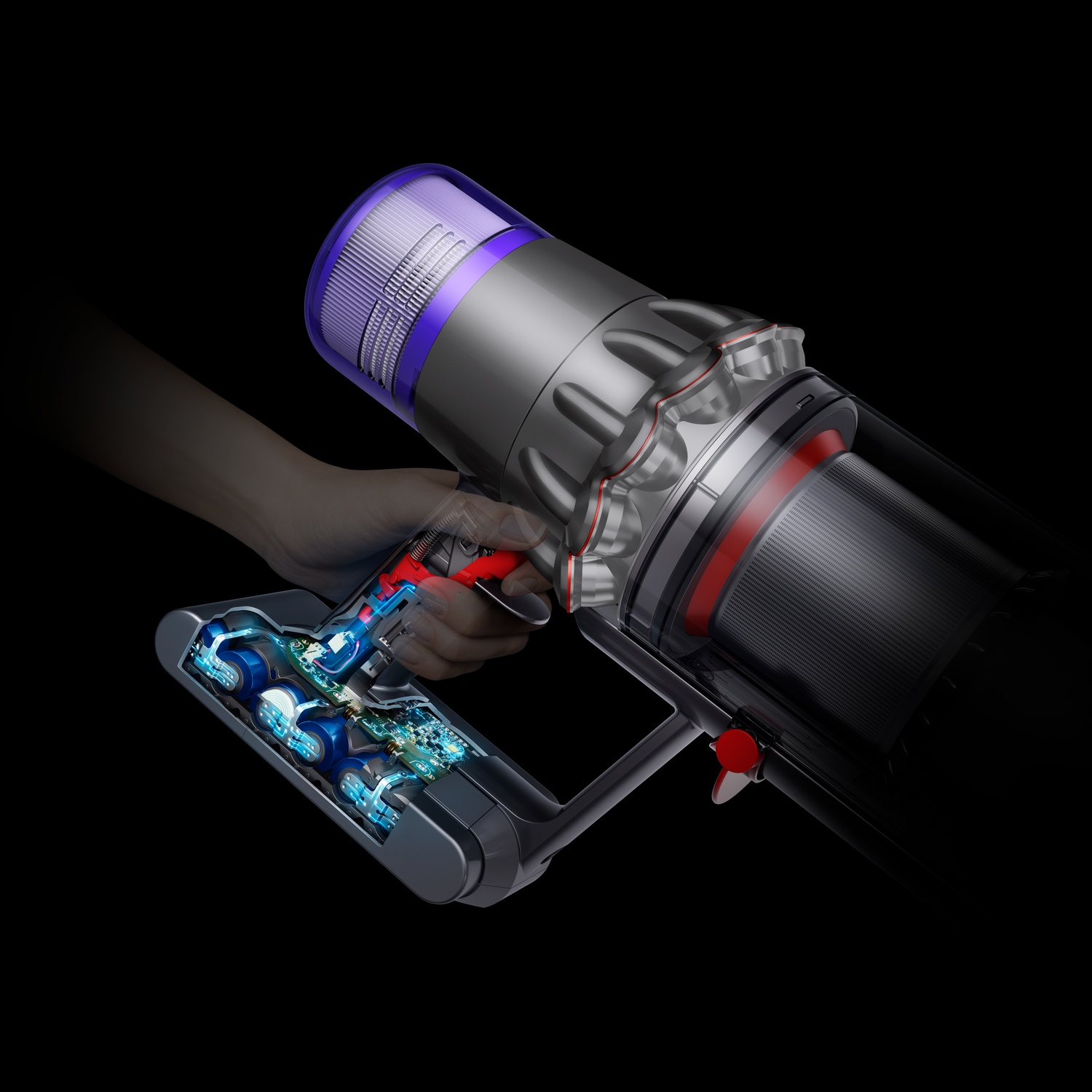 Een hand houdt een Dyson stofzuiger vast. Hij is zilver en zwart met rode accenten. De interne componenten zijn zichtbaar, blauw verlicht.
