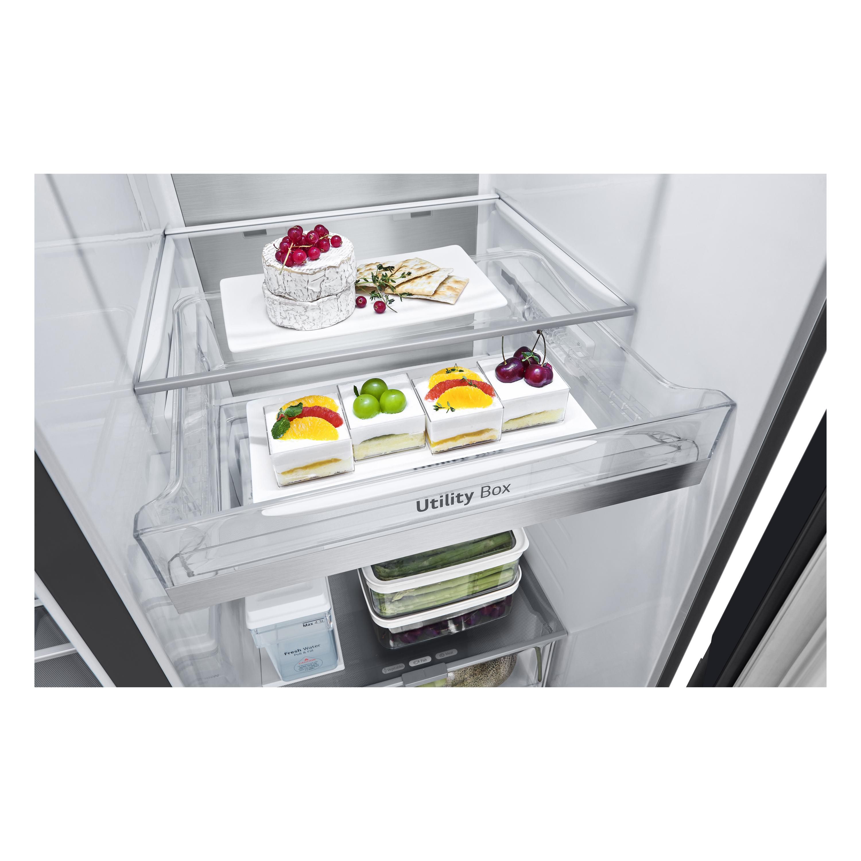 Kühlschrankinnenraum. Käse mit Beeren, Cracker und Desserts in Schubladen. Spargel und andere Gegenstände sind sichtbar.
