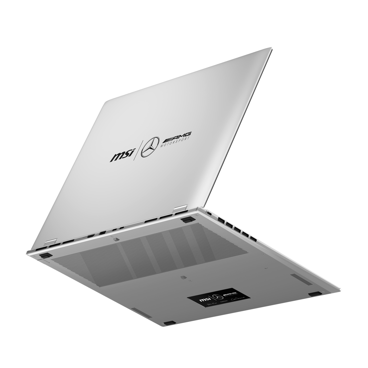 A silver laptop, slightly open, viewed from below. The lid displays MSI and AMG Motorsport logos. The bottom has ventilation holes.