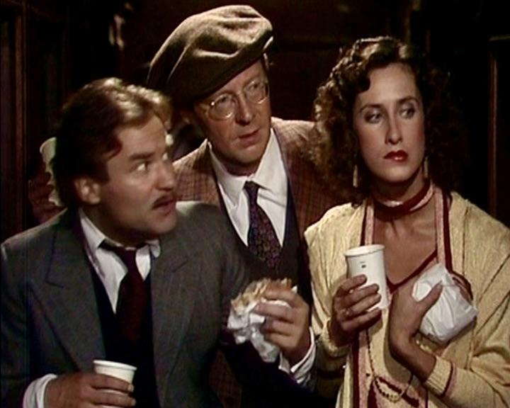 Drei Personen in Vintage-Kleidung, eine hält eine Tasse, eine andere ein Sandwich. Frau mit Locken, roter Lippenstift. Mann mit Baskenmütze.