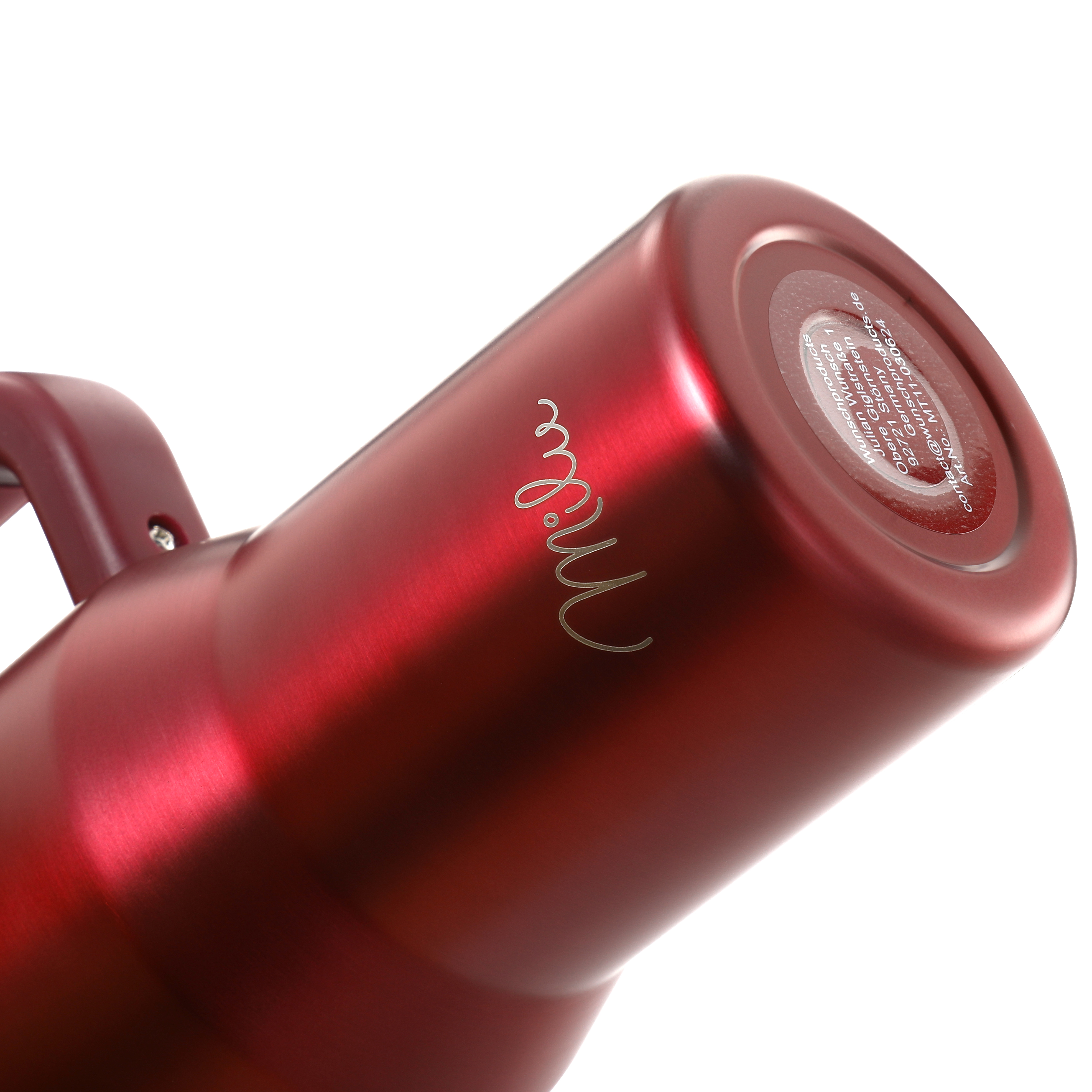 Ein roter Thermobecher mit Henkel ist auf weißem Hintergrund angewinkelt. Das Wort 'Mille' steht seitlich.