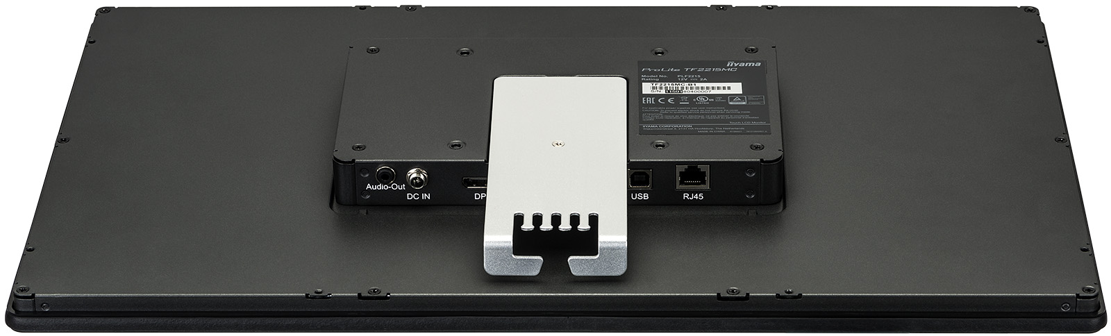 Rückseite eines schwarzen Computermonitors mit verschiedenen Anschlüssen, einer weißen Halterung und einem Produktetikett. Schrauben sind sichtbar.