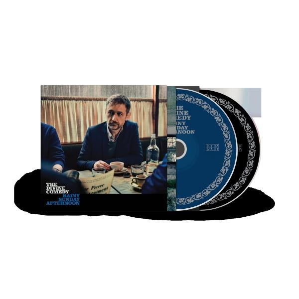 CD-Verpackung von The Divine Comedy. Mann am Tisch, CD sichtbar. Blaue CD mit Text, schwarz-weißes Design. Titel: Rainy Sunday Afternoon.