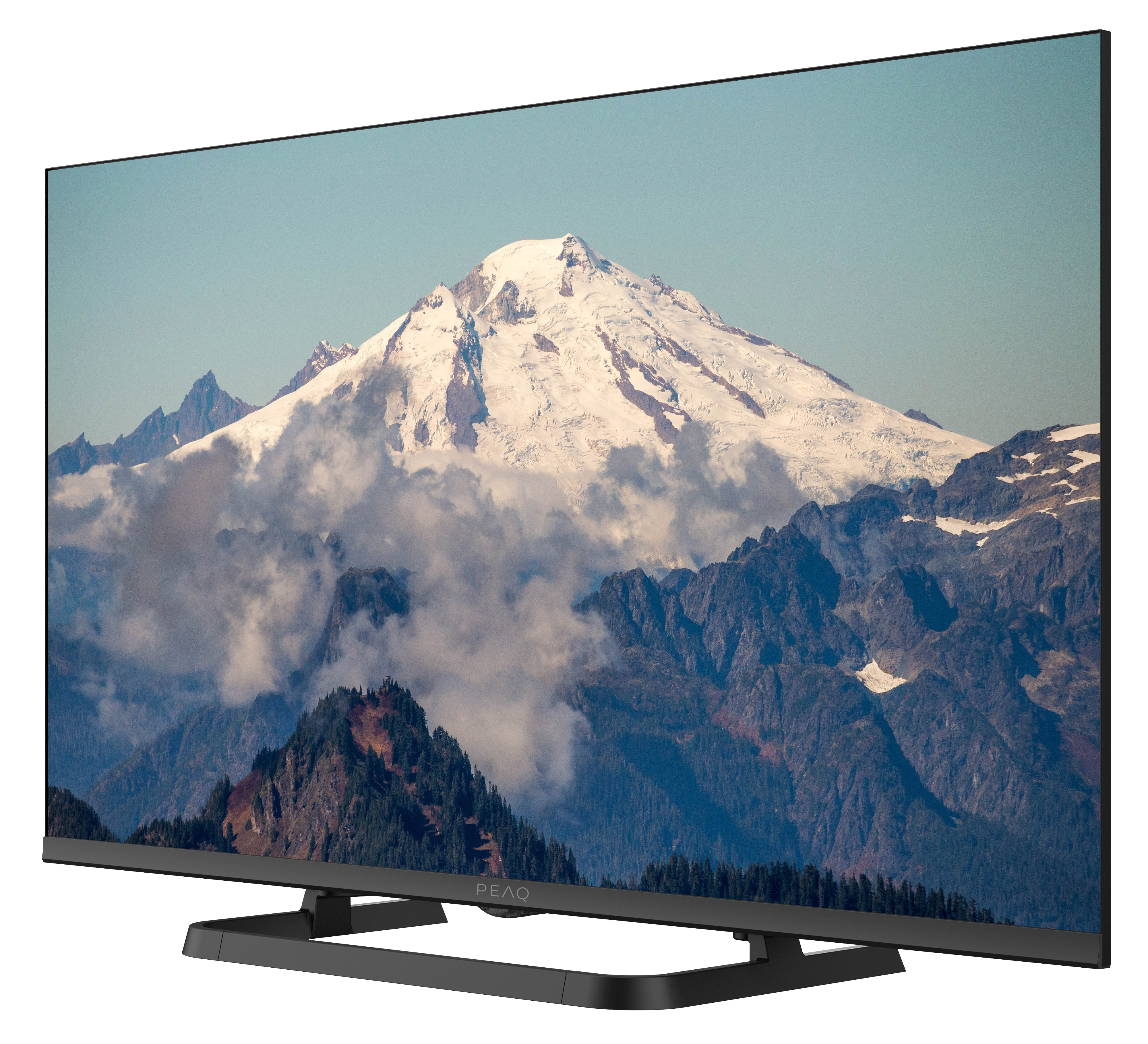 Telewizor wyświetla górski krajobraz ze śniegiem i chmurami. Telewizor jest czarny, na białym tle.