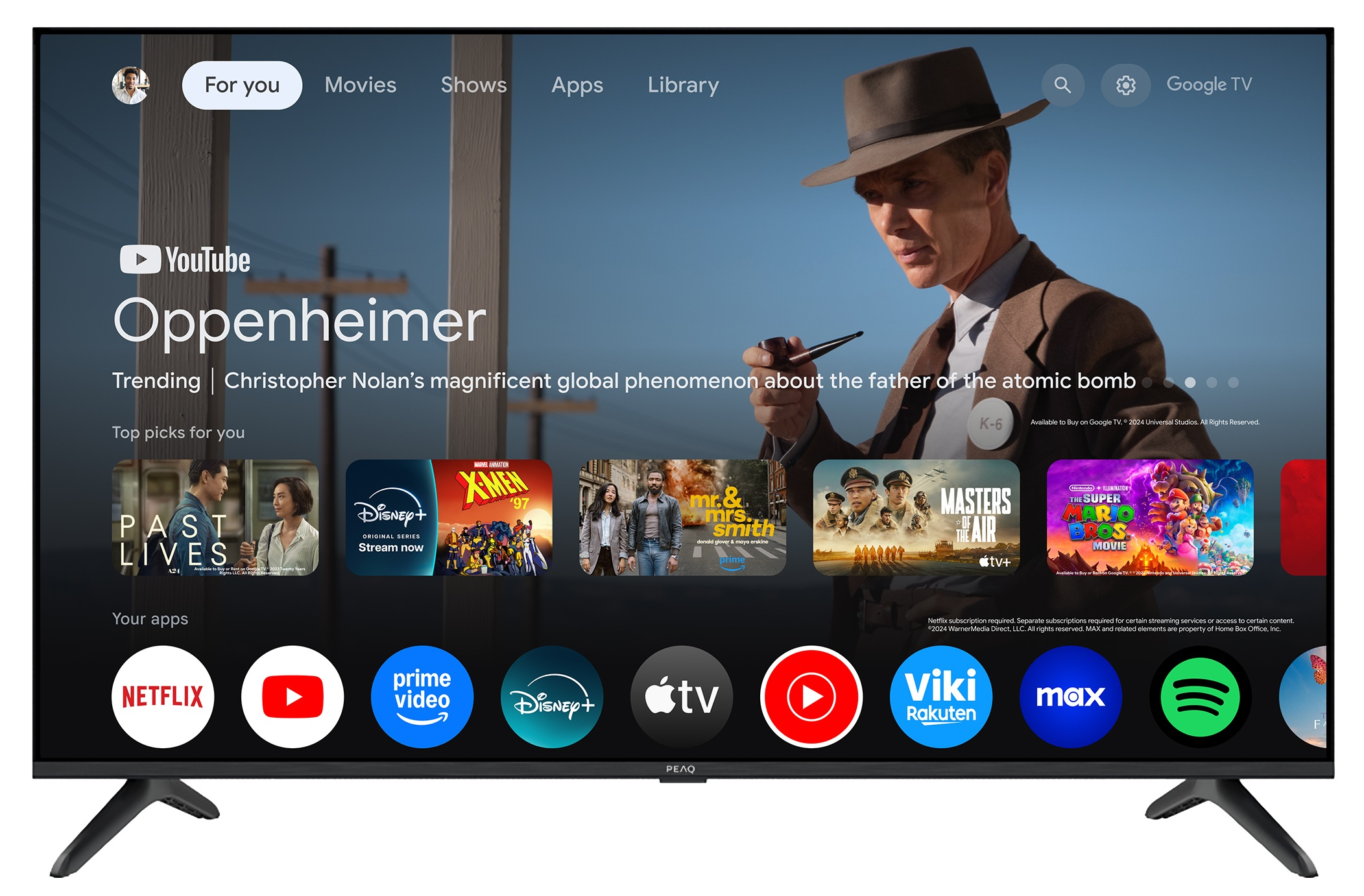 Ekran telewizora wyświetla interfejs Google TV. Film 'Oppenheimer' jest podświetlony z różnymi ikonami aplikacji poniżej.
