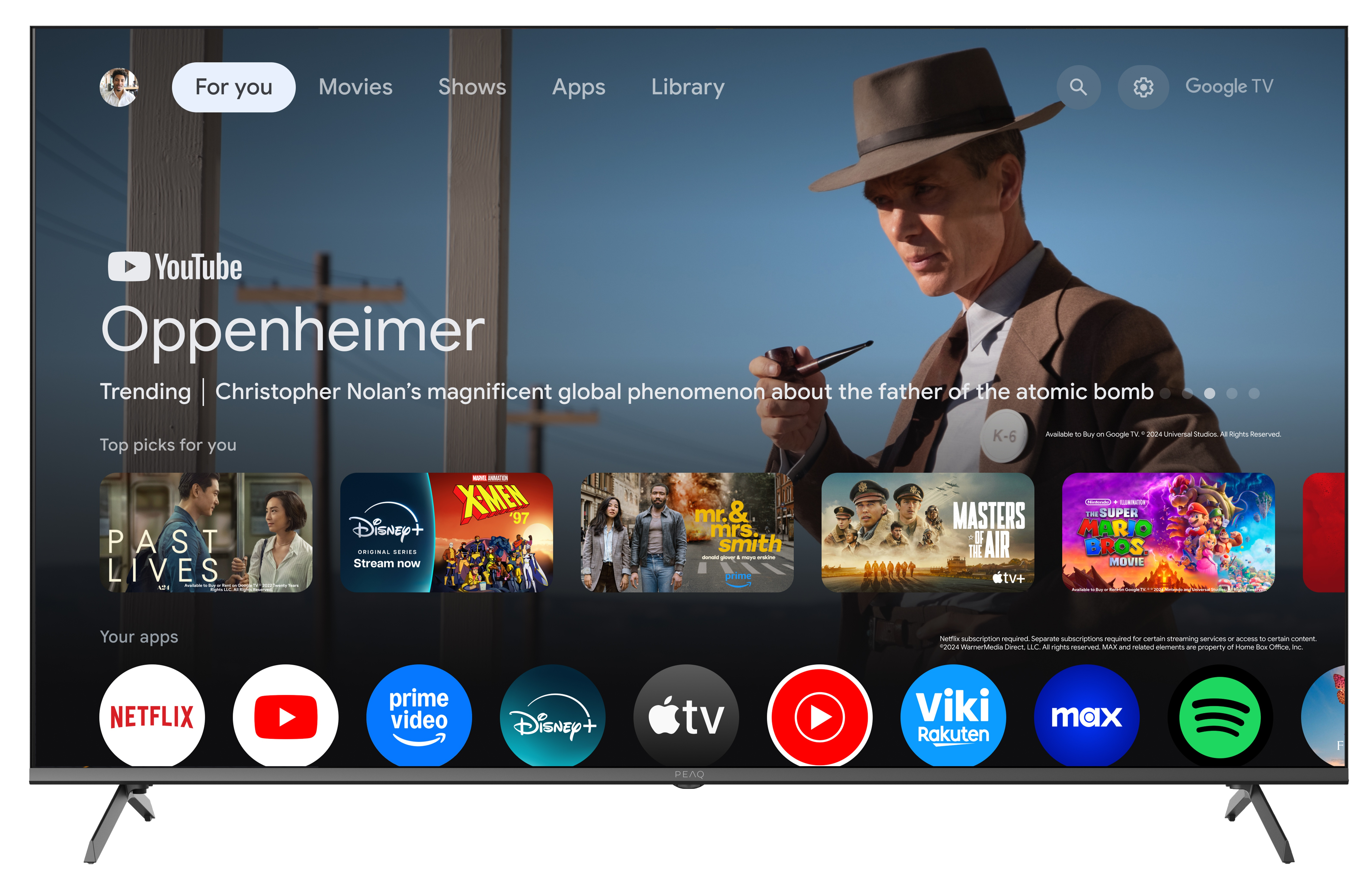 Ekran telewizora z filmem Oppenheimer, aplikacjami i polecanymi filmami. Mężczyzna w kapeluszu po prawej stronie.
