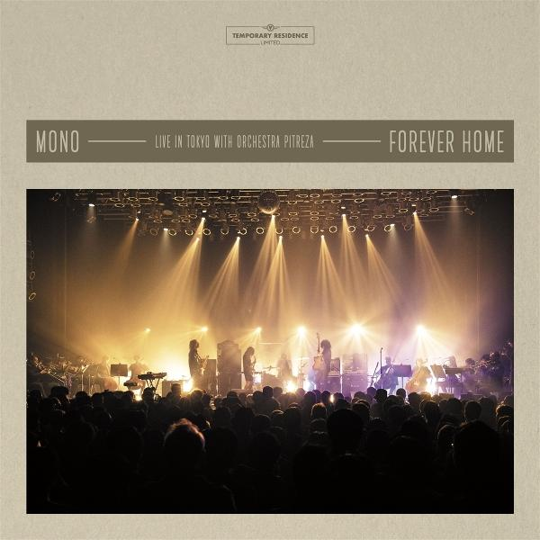 Live-Konzert mit Band auf der Bühne unter hellem Licht. Publikum im Vordergrund. Bühnenhintergrund mit Text: MONO, Forever Home.