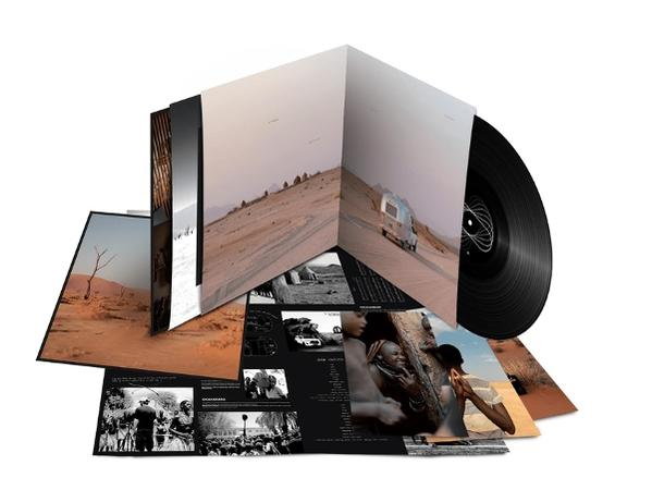 Vinyl-Schallplattenalbum mit offener Verpackung, die eine Wüstenlandschaft und Schwarz-Weiß-Fotos zeigt. Ein Fahrzeug befindet sich auf der Straße.