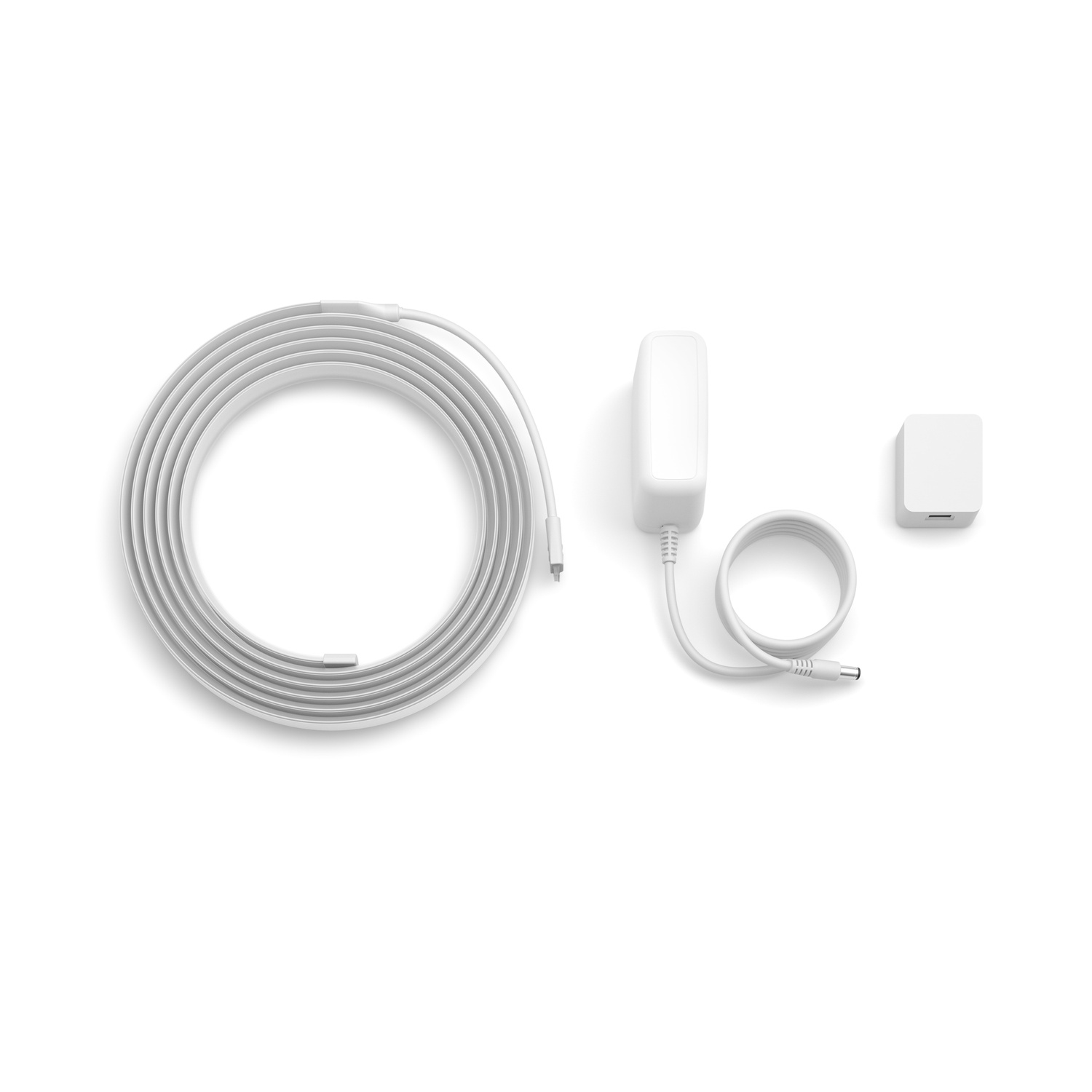 Witte opgerolde kabel, voedingsadapter en klein vierkant apparaat op witte achtergrond. Componenten voor elektronisch apparaat.