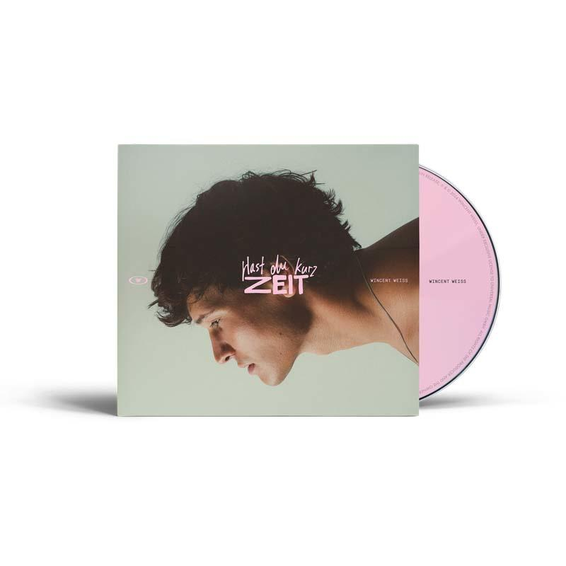 CD-Cover mit Profil eines Mannes, dunklem Haar und Albumtitel 'Hast du kurz Zeit'. Eine rosa CD ist rechts sichtbar.