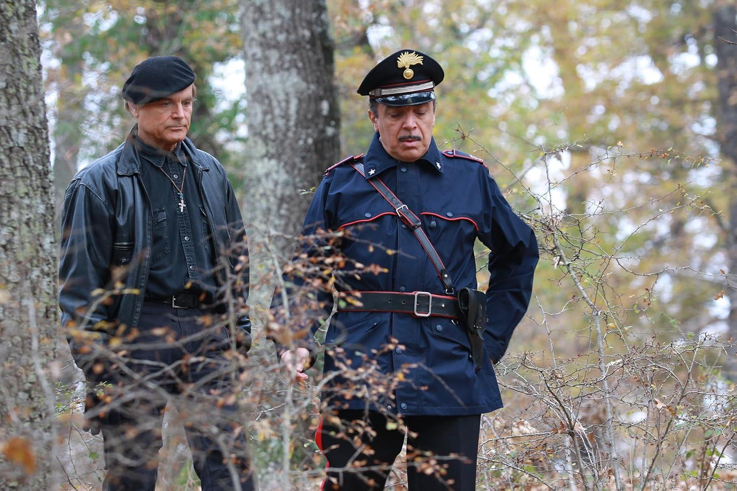 Zwei Männer in einem Wald. Einer trägt Barett und Lederjacke. Der andere trägt Polizeiuniform.
