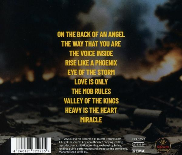 CD-Cover mit Songtiteln und Barcode. Im Hintergrund ein verschwommenes Bild einer zerstörten Gegend. Der Text ist gelb auf dunklem Grund.
