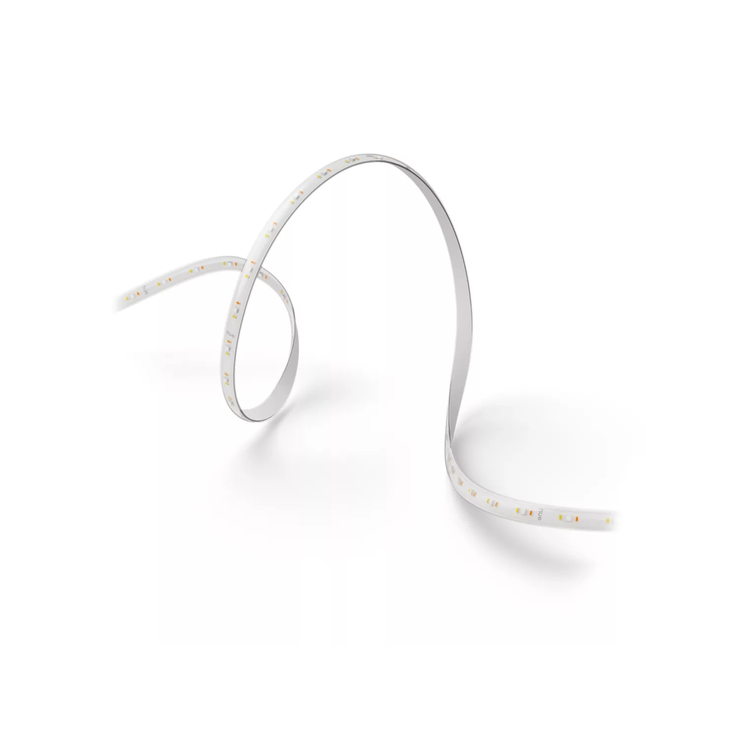 A white LED strip is coiled on a white surface. The strip is lit with small, yellow-orange lights, creating a curve shape.
