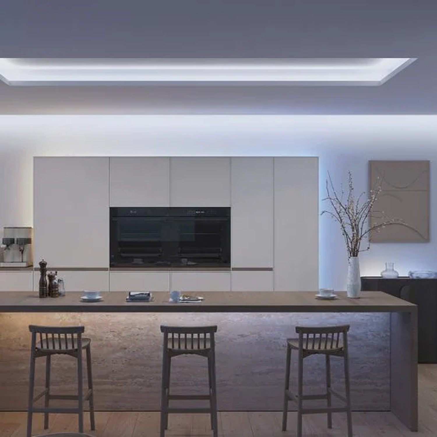 Modern kitchen with island, stools, and built-in appliances. Neutral tones and ambient lighting create a sleek, contemporary design.