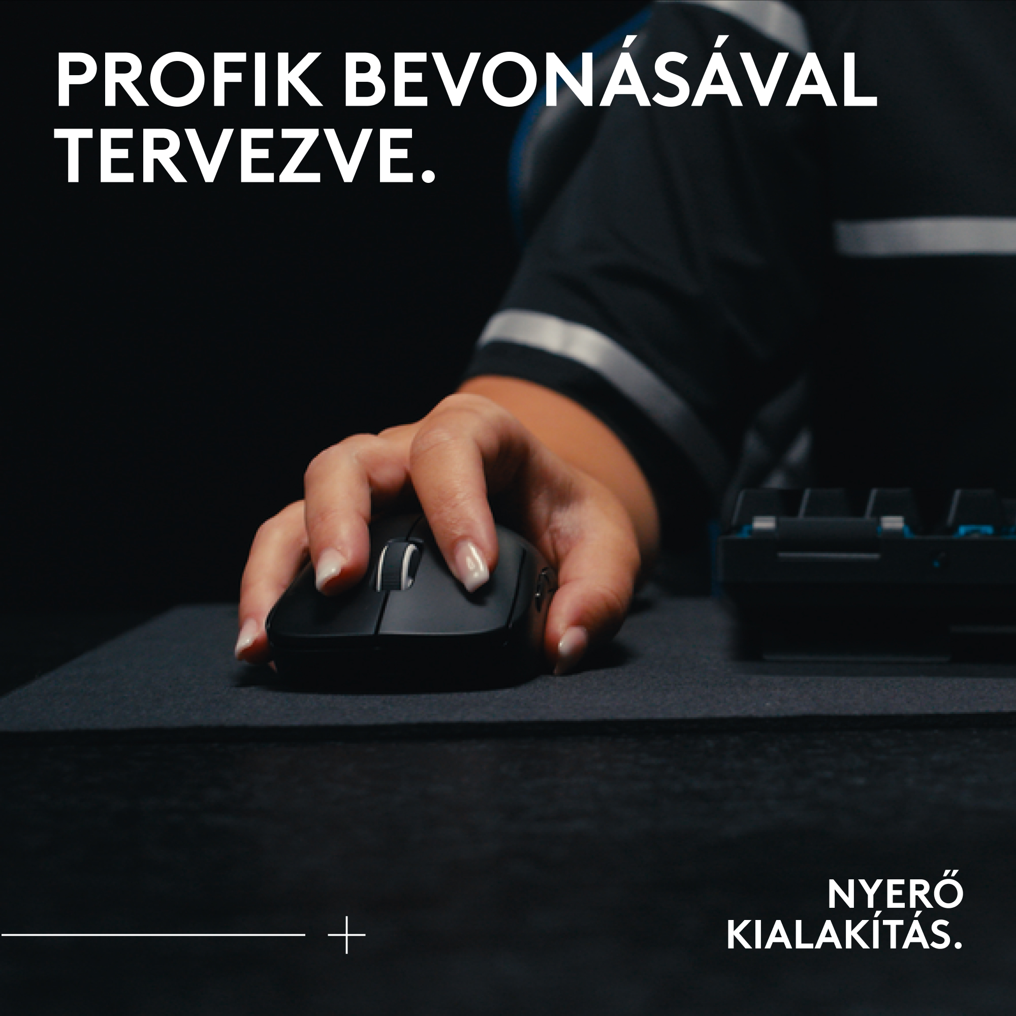 Egy kéz egy fekete egeret tart egy sötét felületen. A háttérben egy billentyűzet látható, felül és alul fehér szöveggel.