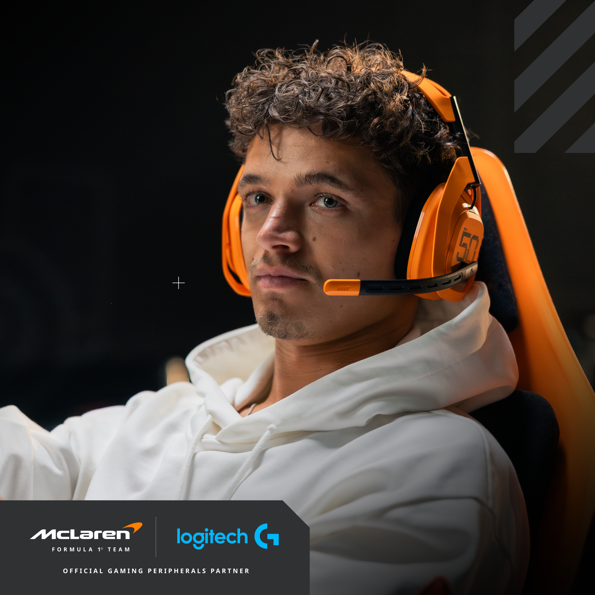 Egy férfi narancssárga fejhallgatóval, egy gamer székben ül, a kamerába néz. A McLaren és a Logitech logói láthatók.