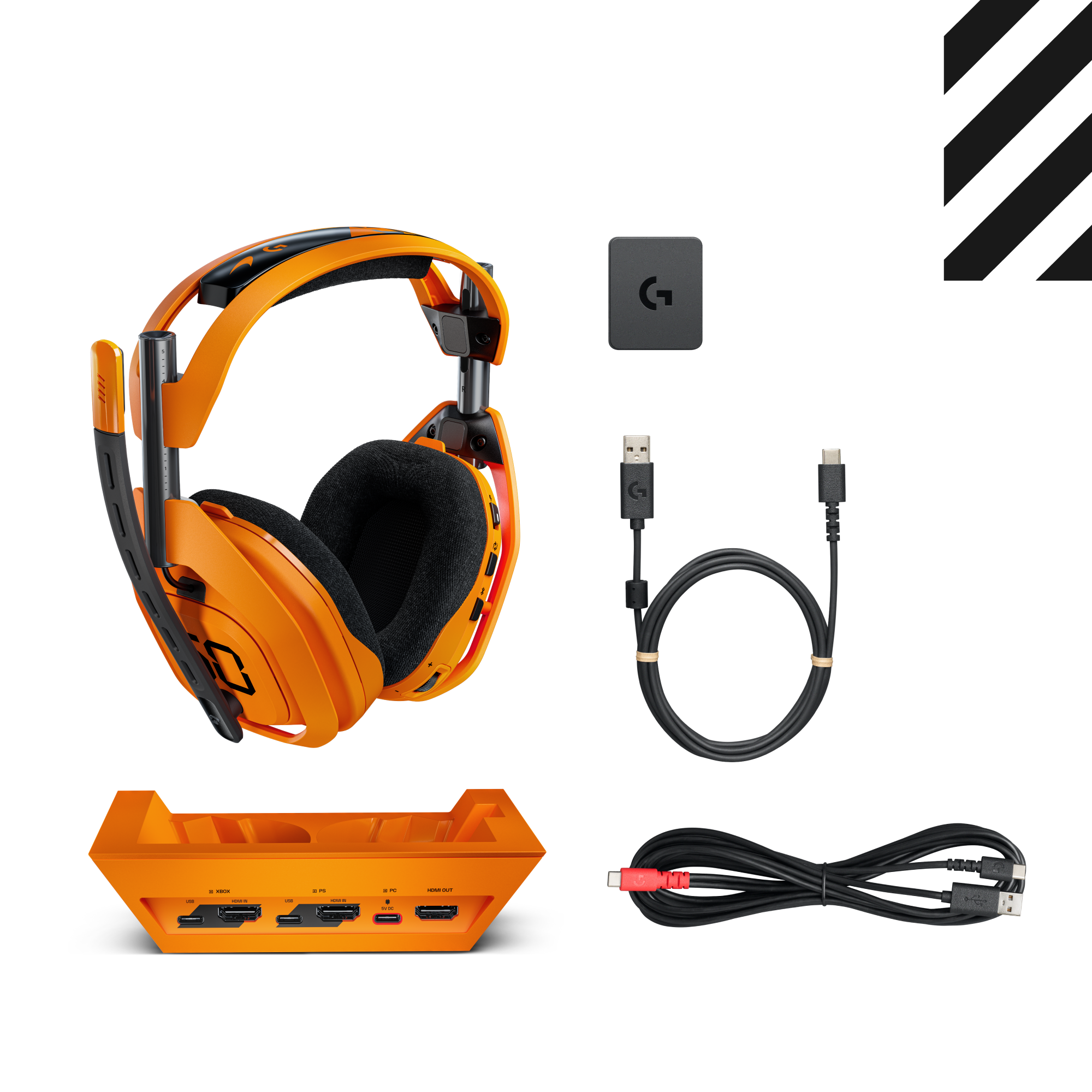 Narancssárga gamer fejhallgató fekete fülpárnákkal, töltőállomás, kábelek és egy kis szürke négyzet. Mindez fehér háttéren.