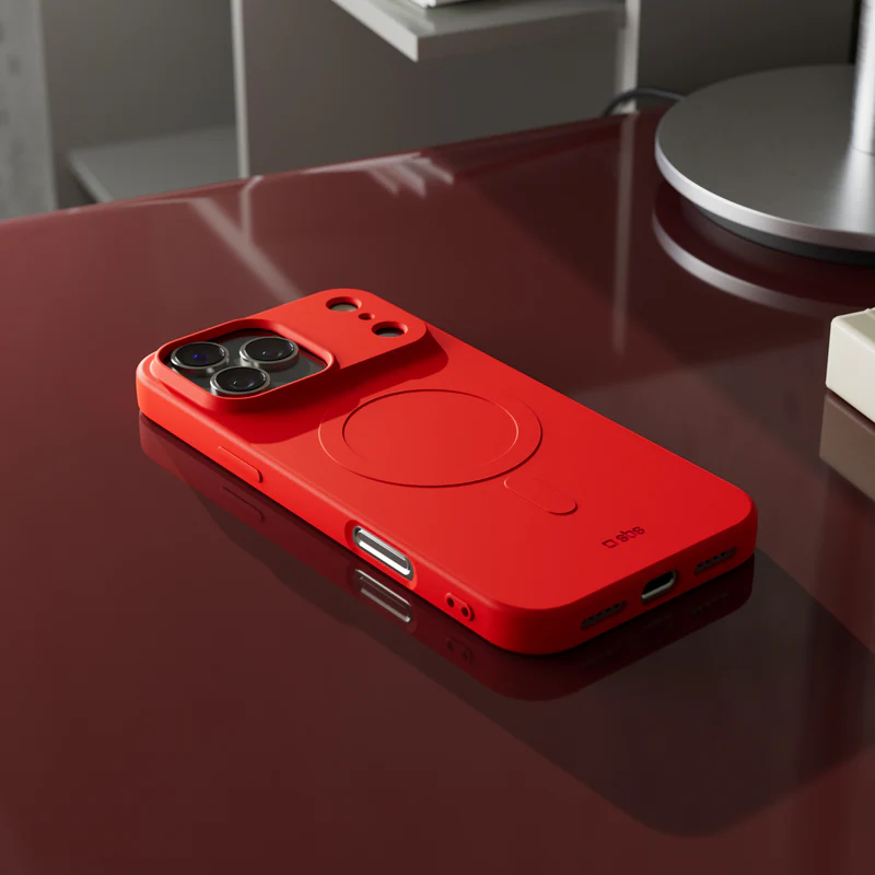 Eine rote Telefonhülle liegt auf einer reflektierenden roten Oberfläche. Die Hülle hat ein kreisförmiges Design und einen Kameraausschnitt.