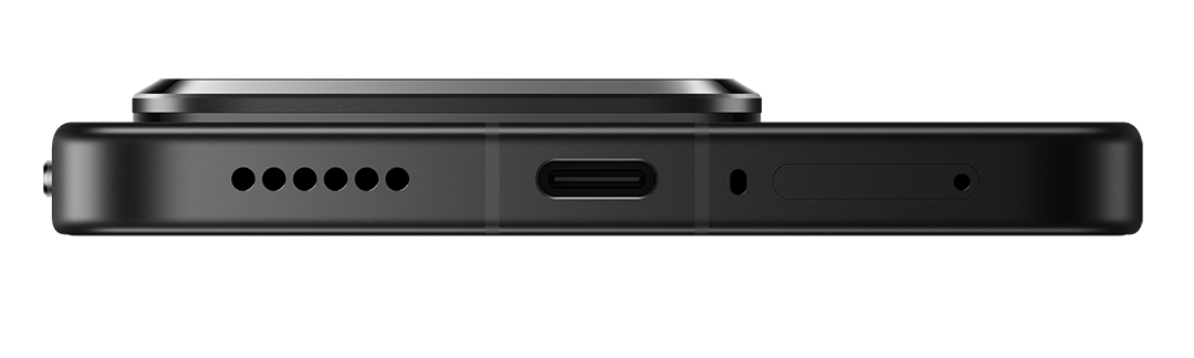Egy fekete okostelefon alsó részének közeli képe. USB-C port, hangszóró lyukak, mikrofon és fém szegély látható.