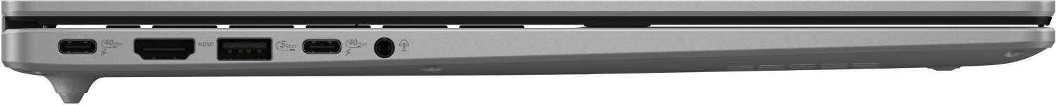 Vista lateral de un portátil plateado. Los puertos visibles incluyen USB-C, HDMI, USB, conector de audio y entrada de alimentación.