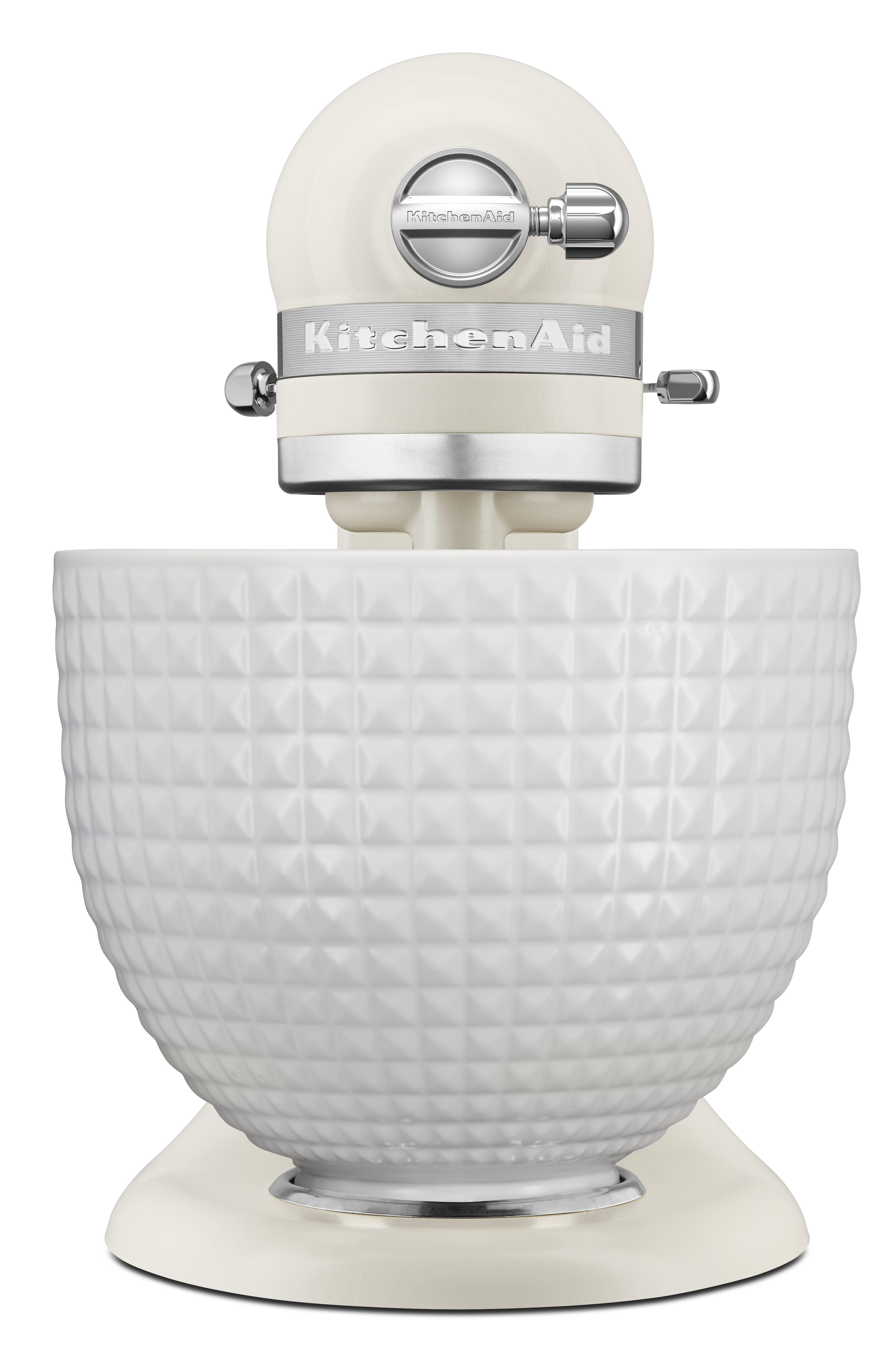 Ein cremefarbener KitchenAid-Küchenmixer mit einer weißen, strukturierten Schüssel, silbernen Akzenten und Markennamen.
