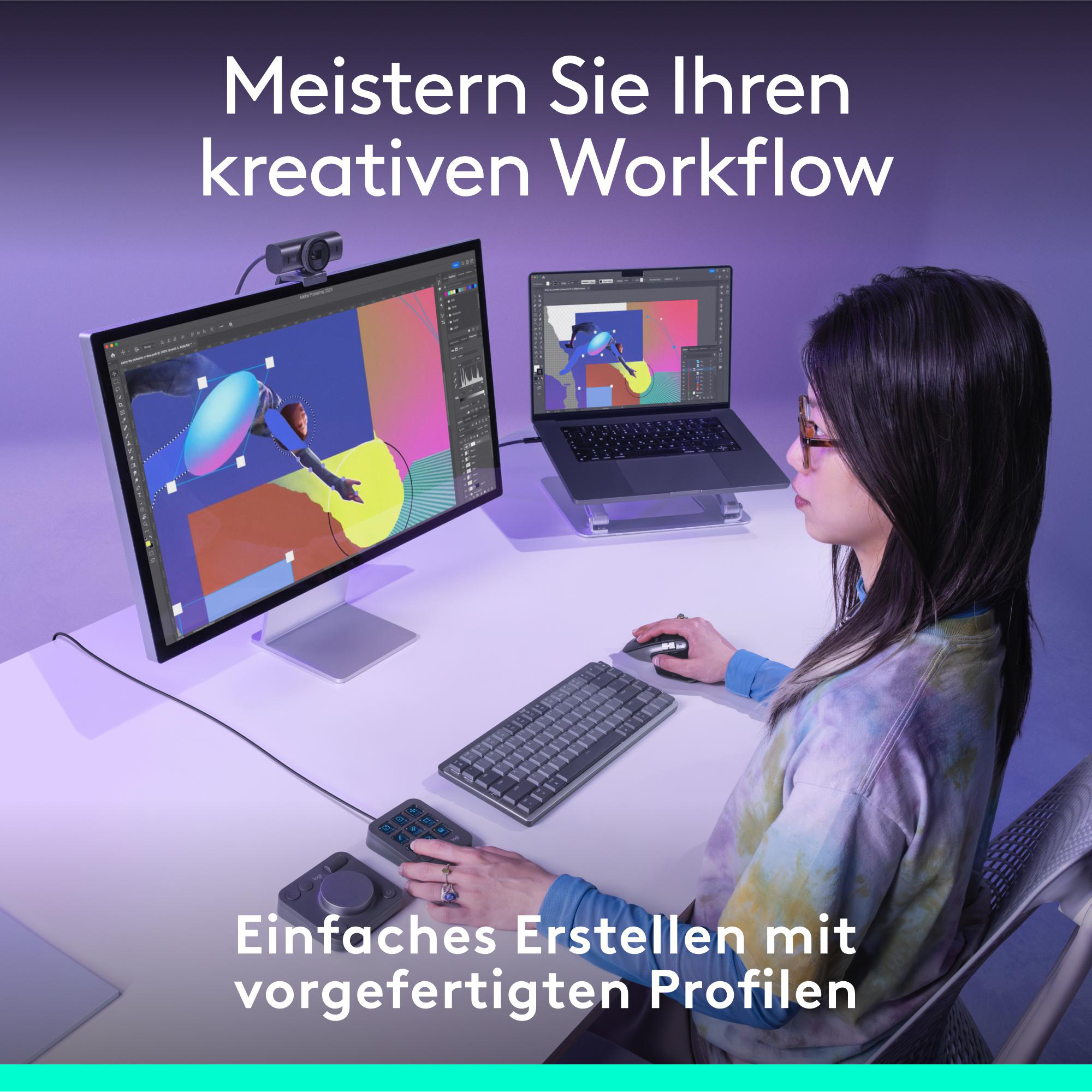 Eine Frau arbeitet an einem Computer mit einem zweiten Laptop. Eine Tastatur und ein Bedienfeld liegen auf dem Schreibtisch.